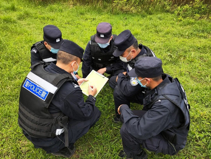 移民管理警察在山林间研究抓捕方案