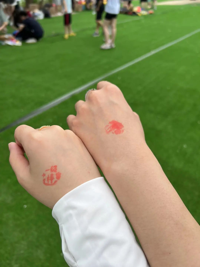 俩人游玩时在手上盖的印章。