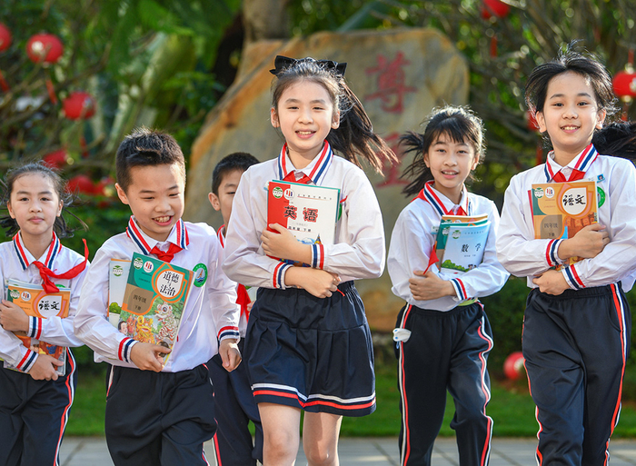 2023年2月12日，海口，港湾小学的学生们领取到新学期课本，展露笑颜。13日，孩子们正式迎来春季学期开学。视觉中国 图