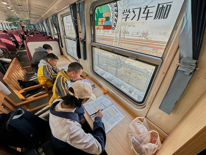 2023年2月9日，学生在5633次列车上读书。新华社记者 薛晨 摄