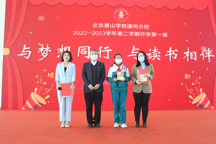 张斌平校长（左二）为师生代表赠送朱永新教授签名版《朱永新谈读书》。受访者供图