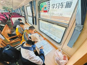 2月9日，学生在5633次列车上写作业。 新华社记者 薛晨 摄