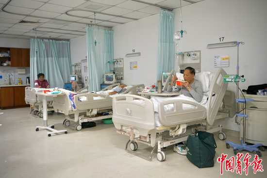     2月9日，北京大学国际医院急诊最后一位新冠阳性病人（右一）正在吃晚饭。中青报·中青网记者 李强/摄