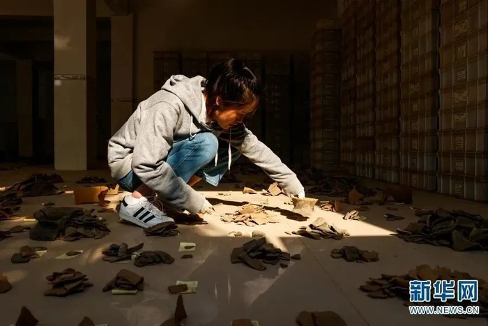 考古工作者对出土的陶片进行分类（摄于2月7日）。新华网 赵普凡 摄