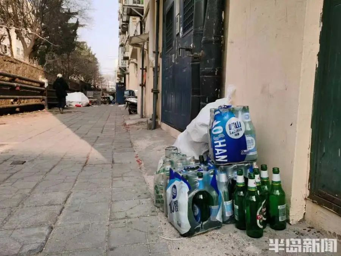西山花苑小区2号楼，角落里堆着许多空啤酒瓶