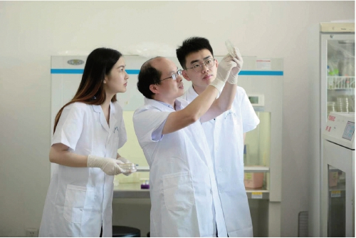 　　童武（左二）和团队成员正在查看细菌生长情况。　受访者供图