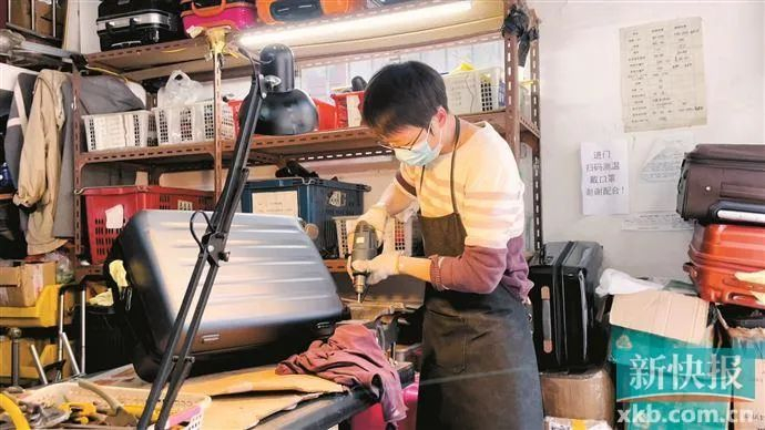 ▲修箱师傅小李在更换行李箱轮子。