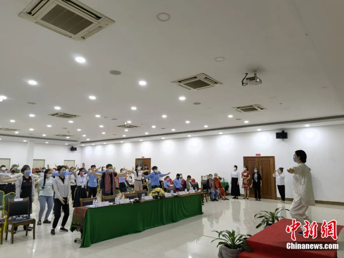 当地时间2022年9月，柬埔寨金边，中国援柬埔寨中医抗疫医疗队成员为大家讲解并示范养生气功操“八段锦”。欧阳开宇摄