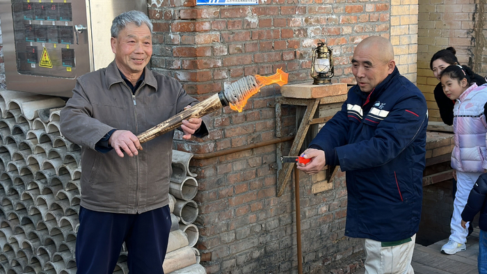 琉璃制作技艺传承人现场传递火把。新京报记者 王巍 摄
