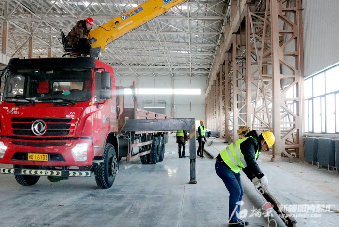 2月14日，工人在三一重能风机制造项目基地吊装行车轨道。王婷摄