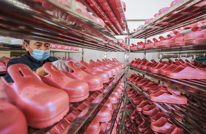 2021年3月8日，福建晋江，凉鞋生产旺季，在福建晋江一鞋厂，工人正在生产线上赶制出口的凉鞋。视觉中国 资料图