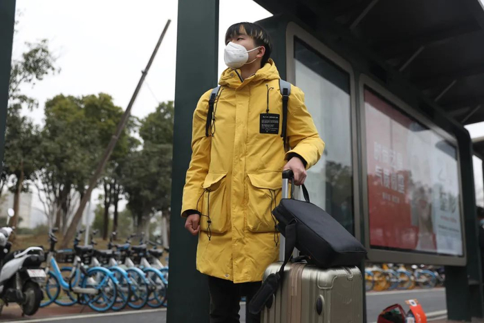 江夏拎着行李等公交车