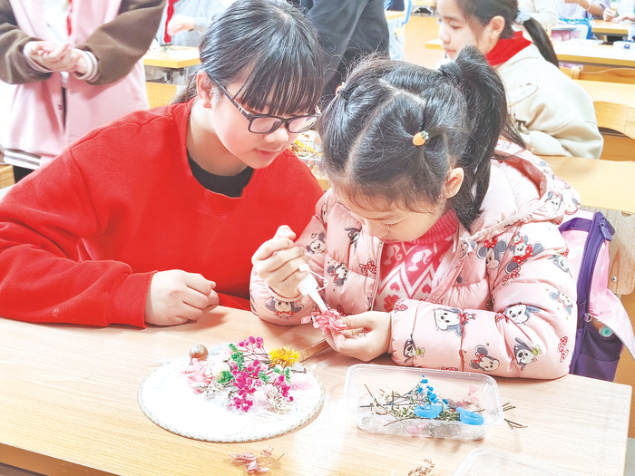    南宁市澳华小学学生利用花叶拼贴装饰宫廷团扇，在动手操作中领略生态花叶创意艺术的魅力。 （学校供图）
