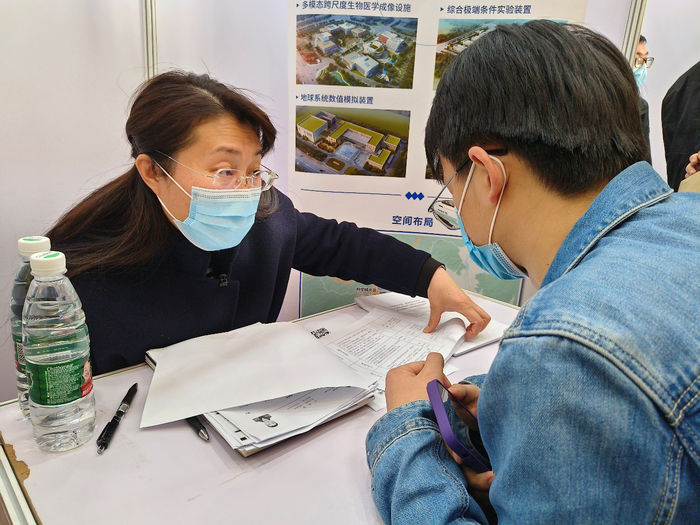 招聘会现场，求职的应届生正在和企业人事专员沟通。新京报记者 叶红梅 摄