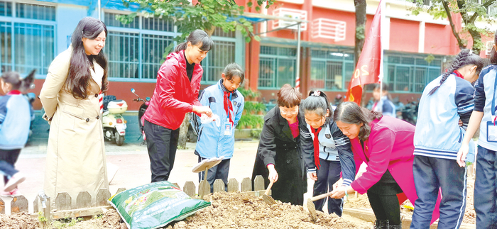     南宁市江南区富宁小学春耕节活动上，学生除草、翻地、松土、播种、浇水。 （万怡 摄）
