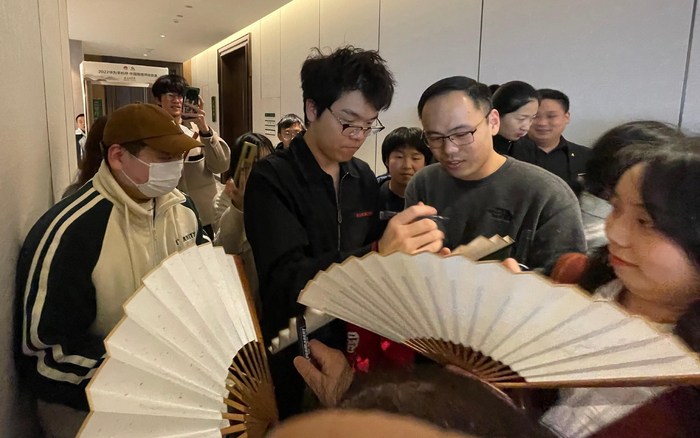 柯洁的人气很高，他在围甲比赛间隙给棋迷签名。  新京报记者 孙海光 摄