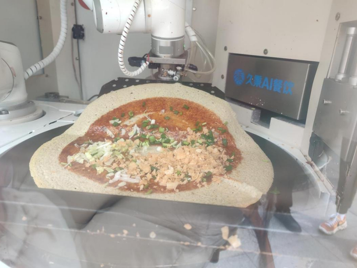 机器人正在把煎饼折叠起来 摄影/王莘莘