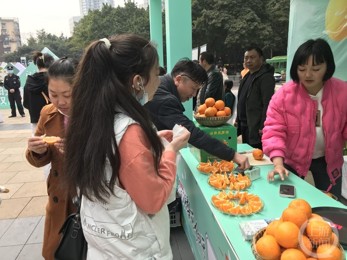 △在现场品尝黄果柑的市民络绎不绝