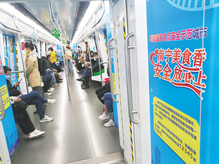    ▲南宁市创建国家食品安全示范城市宣传海报张贴在南宁地铁1号线上，加强食品安全宣教引导，提升公众知晓度。    （何正君 摄）