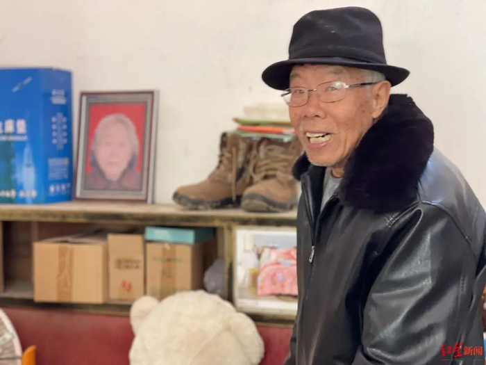 张文明站在老伴的遗像前