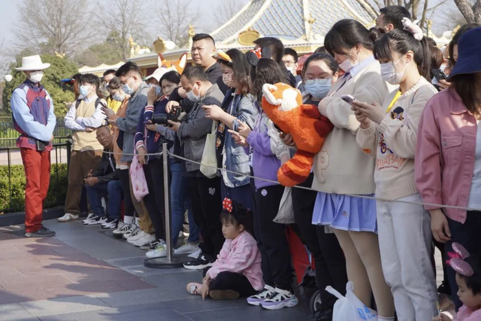 3月10日上午，游客抱着玩偶等候美美出场。