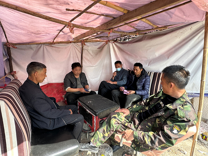 闲暇时，零工们在路口旁的一个简陋帐篷里自娱自乐。