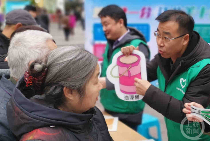 ▲“重庆最美城市管理人”刘景强在向市民宣传垃圾分类