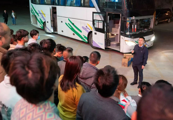 2月12日，云南省曲靖市麒麟区人力资源服务产业园内，全国人大代表袁海波给准备出发的务工人员加油鼓劲（江文耀/摄）