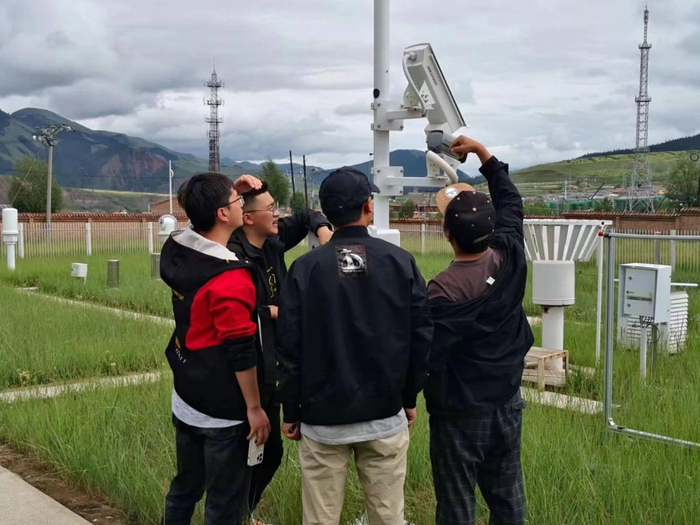 　　在青海省海北藏族自治州祁连县气象局，傅永超（左一）与同事在查看气象监测设备。新华社发