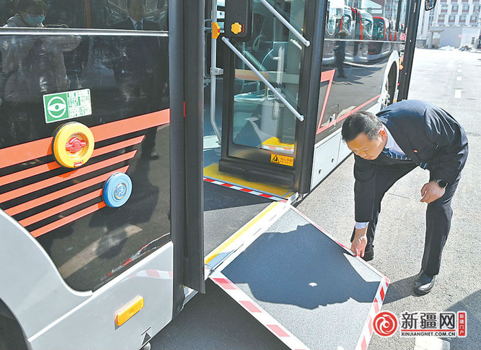 3月23日，安运科负责人周金锐正在演示新能源纯电动公交空调车针对坐轮椅的特殊人群设置的可开合踏板，方便轮椅进出。
