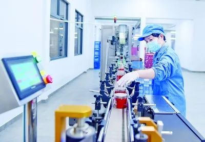 2022年4月，在武夷山市桃渊茗茶叶科学研究所有限公司智能化罐装茶生产车间，员工正在流水线上忙碌。黄杰敏摄/光明图片