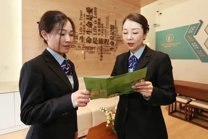 △卫艳茹（右）和工作室工作人员探讨业务