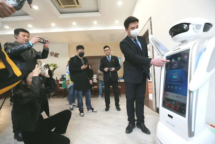 △工作人员向观众展示“智能客服机器人”