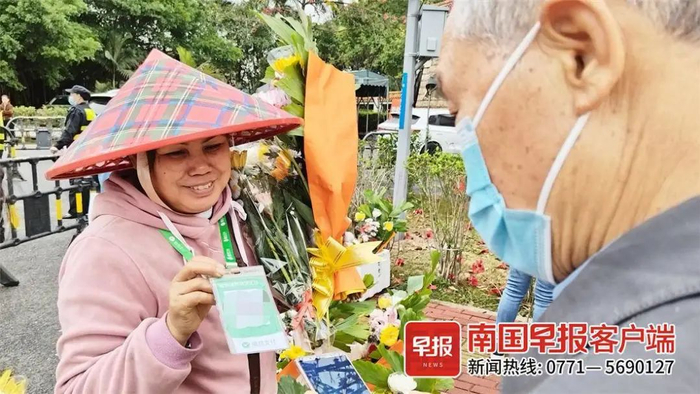 ▲市民正在广西四厦岭墓园前购买鲜花。