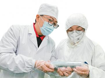 　　潘锦功和工作人员正在检查碲化镉晶体。