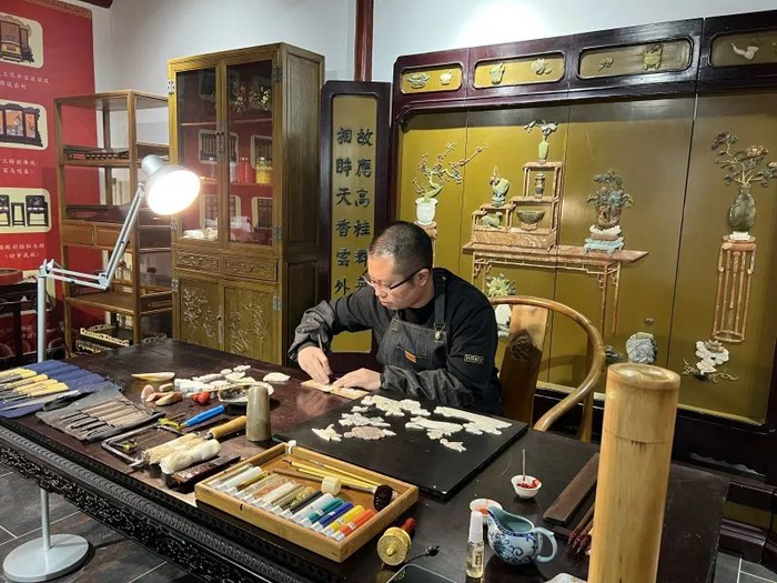 ▲北京市工艺美术金漆镶嵌大师侯雪在燕京八绝博物馆展示镶嵌技艺。受访者供图