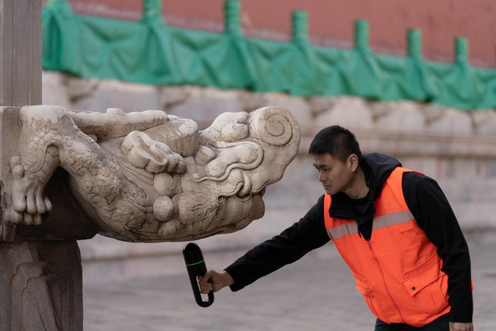 2月19日，测绘人员用手持式三维激光扫描仪，对享殿须弥座台基外侧的螭首进行数据采集。新京报记者 陈杰 摄