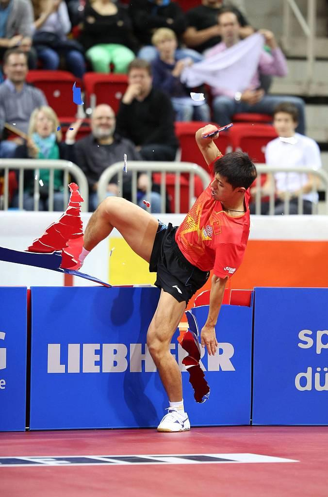 张继科疯狂庆祝踢烂广告牌。  资料图/视觉中国