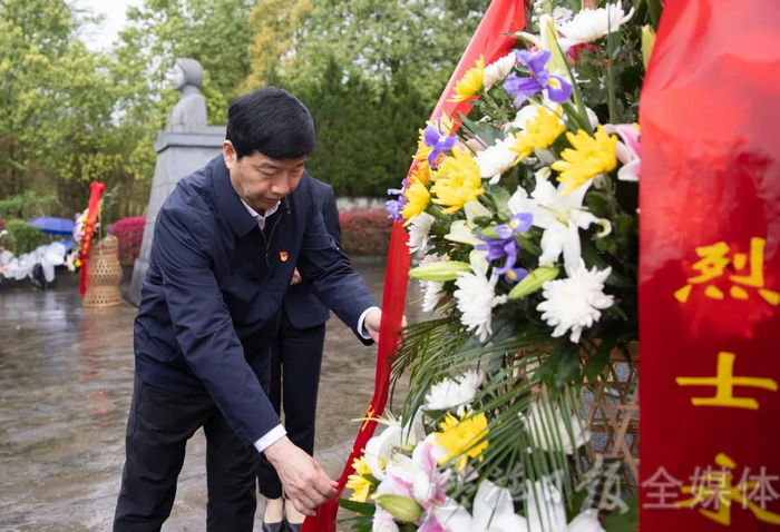 胡超文仔细整理花篮缎带（恩施日报全媒体记者杜磊 摄）