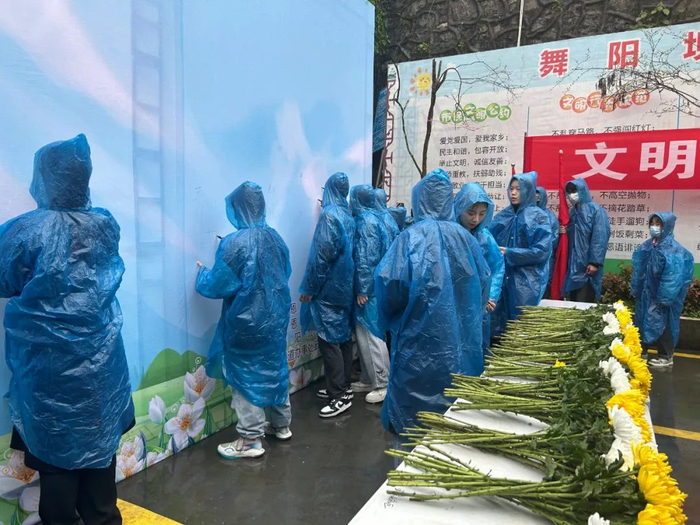 在宣传海报上写下对革命先烈的寄语。