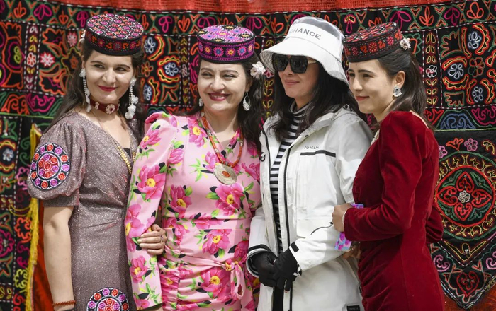 3月24日，一名游客（右二）在新疆塔什库尔干塔吉克自治县大同乡和村民合影。