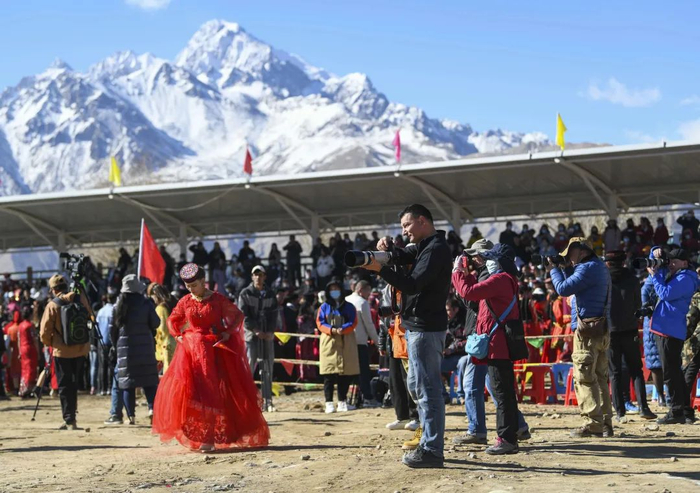 3月21日，游客在新疆塔什库尔干塔吉克自治县肖贡巴哈尔节庆祝活动现场拍摄。
