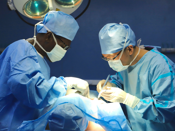 中国第24批援加蓬医疗队总队长兼利伯维尔分队长赵智成在麦伦医院和加蓬当地医生共同为患者实施疝气手术 吴玙琪摄