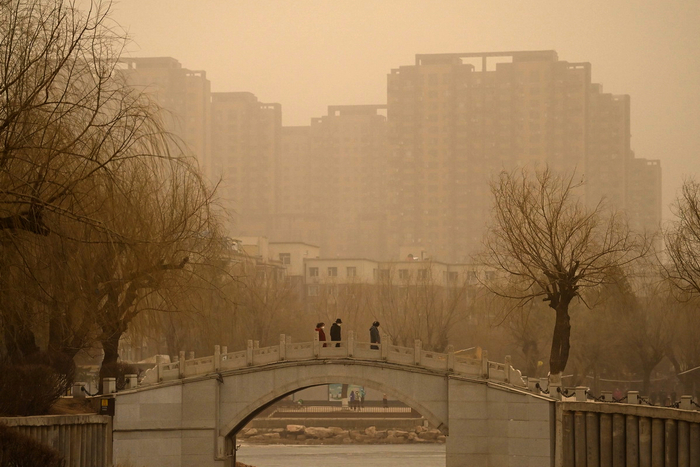 　　3月22日，吉林长春，市民在沙尘天气中出行。长春市气象台当日7时30分发布沙尘蓝色预警信号。 中新社 张瑶 摄