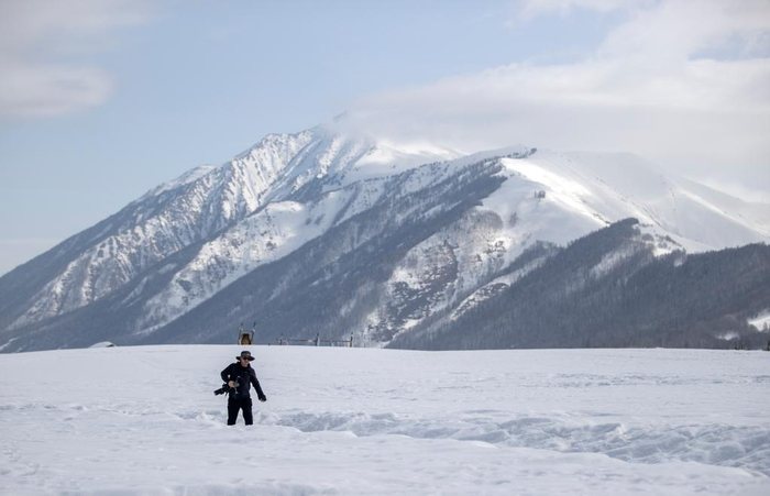 　3月30日，记者李响在雪地中采访拍摄。新华社记者 费茂华 摄