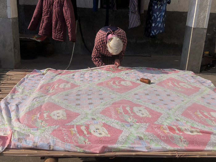 天气好时，外婆在晒被子、缝被子