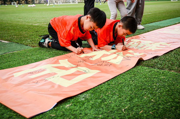 深圳队小球迷在加油横幅上签名。