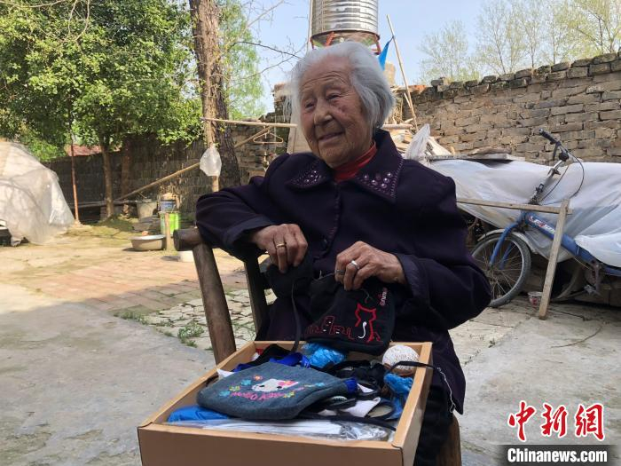 图为4月8日，在世界长寿之乡湖北钟祥，102岁的鞠兰英老人展示自己亲手缝制的零钱袋。中新社记者梁婷摄