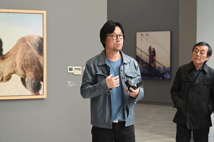 “自我：新纪实摄影”，展览现场。摄影师许海峰介绍自己作品。澎湃新闻记者 吴栋 图