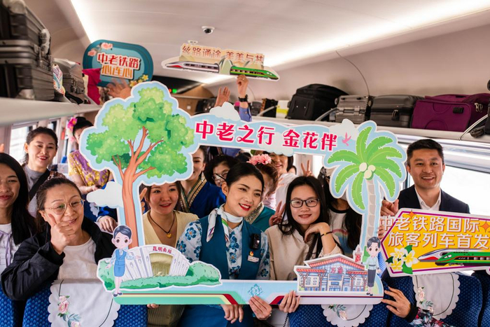 4月13日，乘坐首发列车的旅客和乘务员合影留念。　新华社记者 胡超 摄